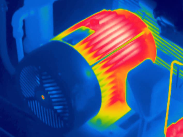 Infrared thermogram of an industrial electric motor: housing and fins running hot, drive end cooler.