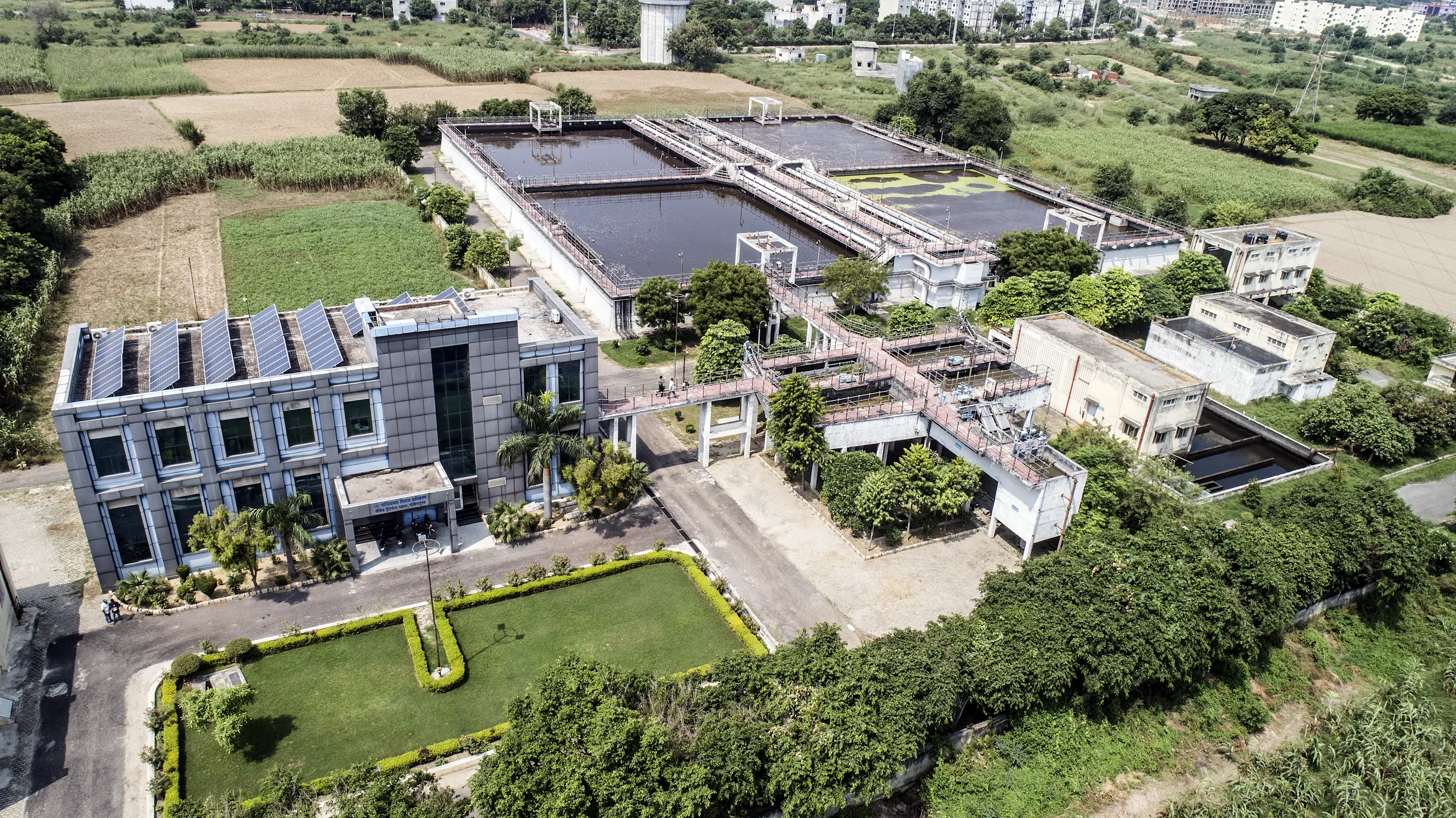 Vista aérea de un complejo industrial con edificio de oficinas y tanques de proceso al aire libre.